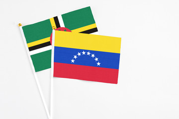 Venezuela and Dominica stick flags on white background. High quality fabric, miniature national flag. Peaceful global concept.White floor for copy space.
