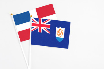 Fototapeta premium Anguilla and Dominican Republic stick flags on white background. High quality fabric, miniature national flag. Peaceful global concept.White floor for copy space.