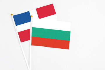 Bulgaria and Dominican Republic stick flags on white background. High quality fabric, miniature national flag. Peaceful global concept.White floor for copy space.