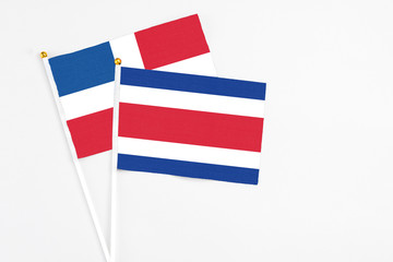 Costa Rica and Dominican Republic stick flags on white background. High quality fabric, miniature national flag. Peaceful global concept.White floor for copy space.