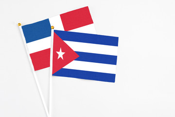 Cuba and Dominican Republic stick flags on white background. High quality fabric, miniature national flag. Peaceful global concept.White floor for copy space.