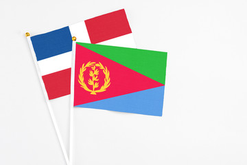 Eritrea and Dominican Republic stick flags on white background. High quality fabric, miniature national flag. Peaceful global concept.White floor for copy space.