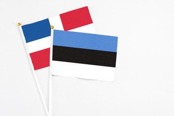 Estonia and Dominican Republic stick flags on white background. High quality fabric, miniature national flag. Peaceful global concept.White floor for copy space.