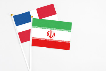 Iran and Dominican Republic stick flags on white background. High quality fabric, miniature national flag. Peaceful global concept.White floor for copy space.
