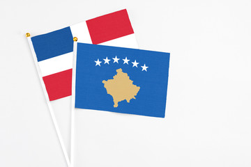 Kosovo and Dominican Republic stick flags on white background. High quality fabric, miniature national flag. Peaceful global concept.White floor for copy space.