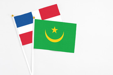 Mauritania and Dominican Republic stick flags on white background. High quality fabric, miniature national flag. Peaceful global concept.White floor for copy space.
