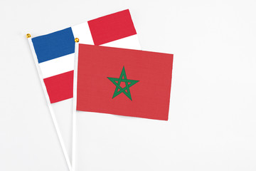 Morocco and Dominican Republic stick flags on white background. High quality fabric, miniature national flag. Peaceful global concept.White floor for copy space.