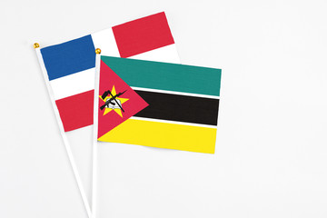 Mozambique and Dominican Republic stick flags on white background. High quality fabric, miniature national flag. Peaceful global concept.White floor for copy space.