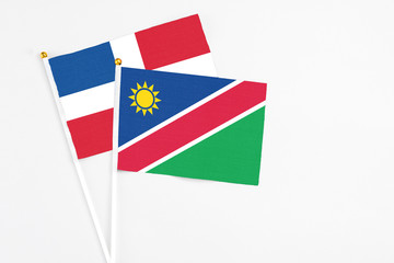 Namibia and Dominican Republic stick flags on white background. High quality fabric, miniature national flag. Peaceful global concept.White floor for copy space.