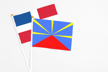 Reunion and Dominican Republic stick flags on white background. High quality fabric, miniature national flag. Peaceful global concept.White floor for copy space.