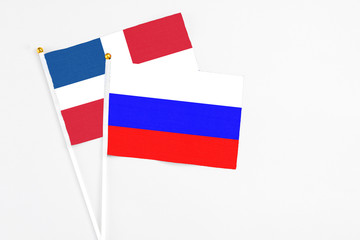 Russia and Dominican Republic stick flags on white background. High quality fabric, miniature national flag. Peaceful global concept.White floor for copy space.