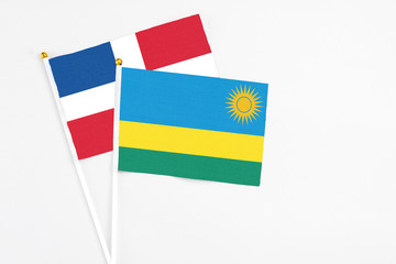 Rwanda and Dominican Republic stick flags on white background. High quality fabric, miniature national flag. Peaceful global concept.White floor for copy space.