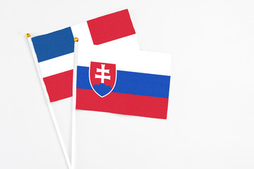 Slovakia and Dominican Republic stick flags on white background. High quality fabric, miniature national flag. Peaceful global concept.White floor for copy space.