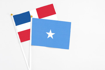 Somalia and Dominican Republic stick flags on white background. High quality fabric, miniature national flag. Peaceful global concept.White floor for copy space.