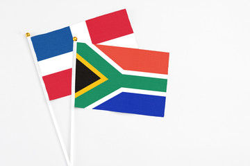 South Africa and Dominican Republic stick flags on white background. High quality fabric, miniature national flag. Peaceful global concept.White floor for copy space.