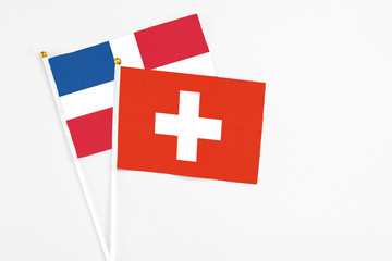 Switzerland and Dominican Republic stick flags on white background. High quality fabric, miniature national flag. Peaceful global concept.White floor for copy space.
