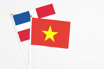 Vietnam and Dominican Republic stick flags on white background. High quality fabric, miniature national flag. Peaceful global concept.White floor for copy space.