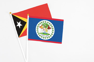 Belize and East Timor stick flags on white background. High quality fabric, miniature national flag. Peaceful global concept.White floor for copy space.