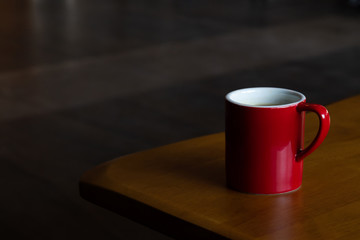 mug of hot americano black coffee on the top of the wooden table with morning light at the coffee shop. coffee break for refreshing in the working time.