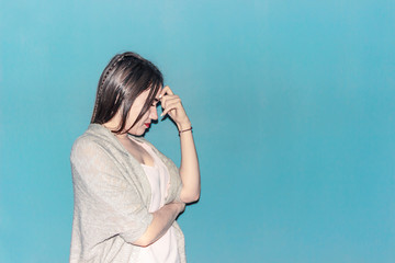 Girl with a headache leaning her hand to her head is trying to alleviate the pain in her head.