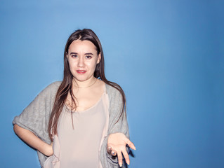 Smiling girl with good emotions shows product by hand.