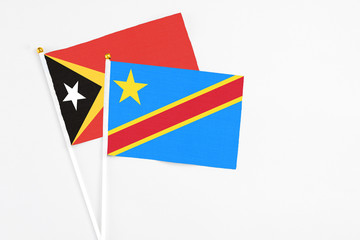 Congo and East Timor stick flags on white background. High quality fabric, miniature national flag. Peaceful global concept.White floor for copy space.