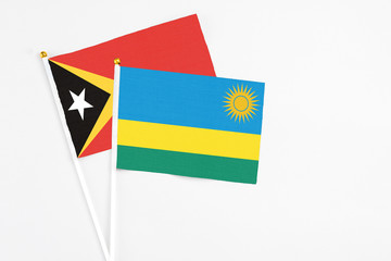 Rwanda and East Timor stick flags on white background. High quality fabric, miniature national flag. Peaceful global concept.White floor for copy space.