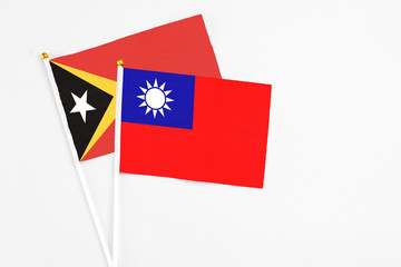 Taiwan and East Timor stick flags on white background. High quality fabric, miniature national flag. Peaceful global concept.White floor for copy space.