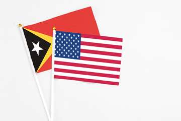 United States and East Timor stick flags on white background. High quality fabric, miniature national flag. Peaceful global concept.White floor for copy space.
