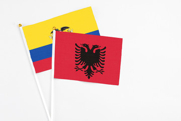 Albania and Ecuador stick flags on white background. High quality fabric, miniature national flag. Peaceful global concept.White floor for copy space.