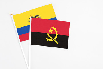 Angola and Ecuador stick flags on white background. High quality fabric, miniature national flag. Peaceful global concept.White floor for copy space.