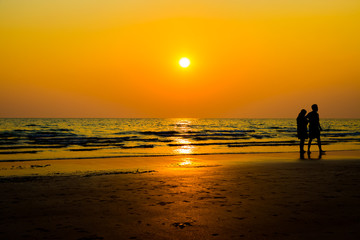 Fototapeta na wymiar Siluate lovers and beach before sunset