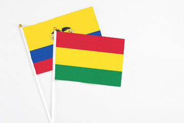 Bolivia and Ecuador stick flags on white background. High quality fabric, miniature national flag. Peaceful global concept.White floor for copy space.