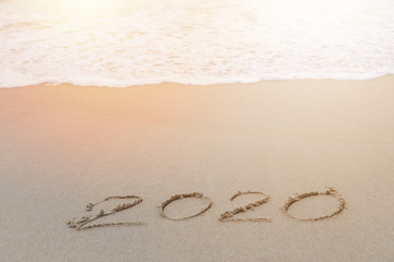 2020 written in the sand on the beach