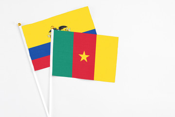 Fototapeta premium Cameroon and Ecuador stick flags on white background. High quality fabric, miniature national flag. Peaceful global concept.White floor for copy space.