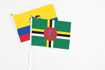 Dominica and Ecuador stick flags on white background. High quality fabric, miniature national flag. Peaceful global concept.White floor for copy space.
