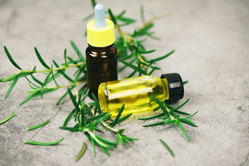 Essential oil bottle natural spa ingredients rosemary oil for aromatherapy and rosemary leaf on sack background - Organic cosmetics with extracts of herbs
