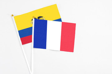 France and Ecuador stick flags on white background. High quality fabric, miniature national flag. Peaceful global concept.White floor for copy space.