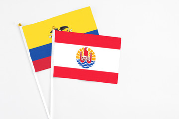 French Polynesia and Ecuador stick flags on white background. High quality fabric, miniature national flag. Peaceful global concept.White floor for copy space.