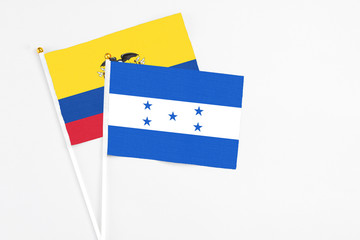 Honduras and Ecuador stick flags on white background. High quality fabric, miniature national flag. Peaceful global concept.White floor for copy space.
