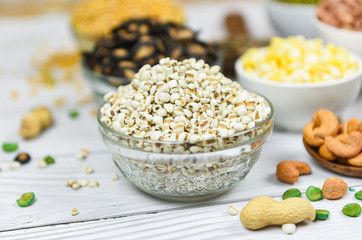 Adlay millet or pearl millet white Job's tears on bowl - Coix Lachrymal adlay jobi with different whole grains beans and legumes seeds background
