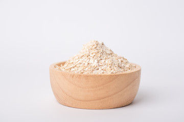 Close up of oat flake in a brown wooden bowl on a white background