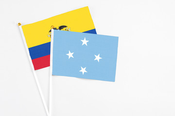 Micronesia and Ecuador stick flags on white background. High quality fabric, miniature national flag. Peaceful global concept.White floor for copy space.