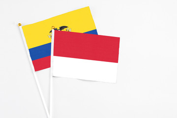Monaco and Ecuador stick flags on white background. High quality fabric, miniature national flag. Peaceful global concept.White floor for copy space.