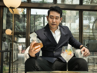 Handsome Asian businessman drinking fusion tea in cafe, lifestyle