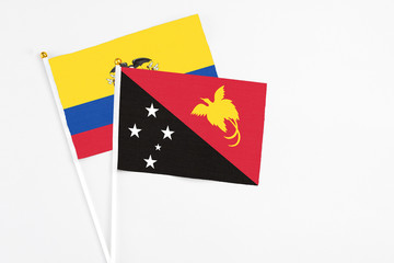 Papua New Guinea and Ecuador stick flags on white background. High quality fabric, miniature national flag. Peaceful global concept.White floor for copy space.