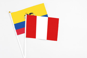 Peru and Ecuador stick flags on white background. High quality fabric, miniature national flag. Peaceful global concept.White floor for copy space.