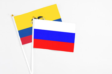 Russia and Ecuador stick flags on white background. High quality fabric, miniature national flag. Peaceful global concept.White floor for copy space.