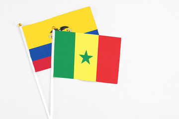 Senegal and Ecuador stick flags on white background. High quality fabric, miniature national flag. Peaceful global concept.White floor for copy space.