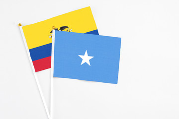 Somalia and Ecuador stick flags on white background. High quality fabric, miniature national flag. Peaceful global concept.White floor for copy space.
